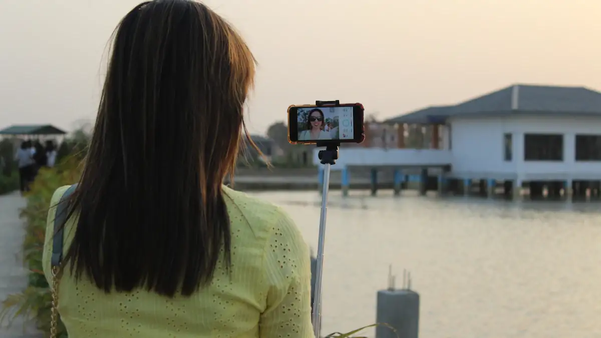 Person recording a vertical video on a phone by a lake
